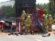   Firefighters stand in front of a crushed truck cabin on a highway. © TeleNewsNetwork 