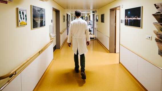 Ein Arzt geht über den Flur eines Krankenhauses. © NDR Foto: Julius Matuschik