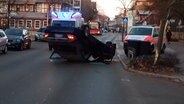 A car is lying on a road on the roof, next to an ambulance and an ambulance. © Lüneburg Police Inspectorate 