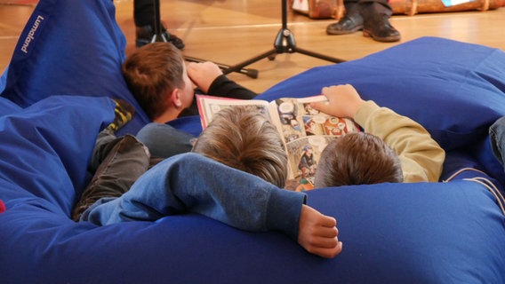 Kinder lesen auf der 49. Kinder- und Jugendbuchmesse in neu erschienenen Kinderbüchern. © NDR Foto: Helgard Füchsel