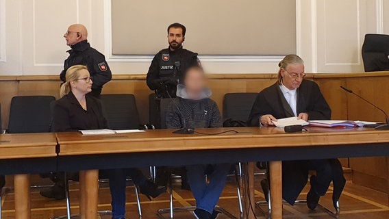 Der Angeklagte eines Mordprozesses im Landgericht Osnabrück zwischen seiner Dolmetscherin und seinem Anwalt © NDR Foto: Susanne Schäfer