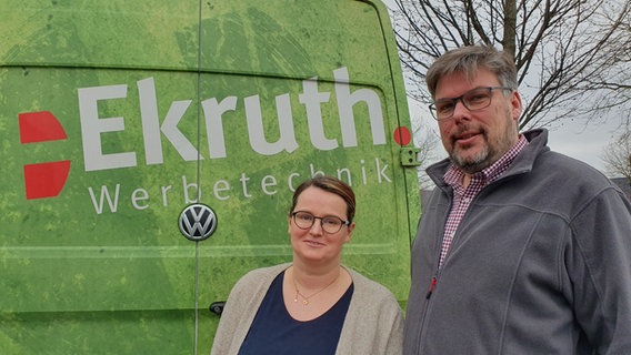 Eine Frau und ein Mann stehen vor einem Fahrzeug auf dem "Ekruth" steht. © NDR Foto: Susanne Schäfer