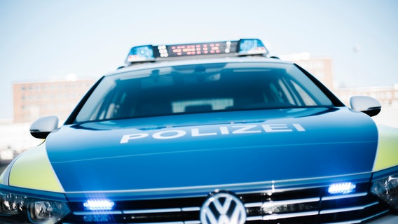 Ein Polizeiauto von vorne mit eingeschaltetem Blaulicht. © NDR Foto: Julius Matuschik