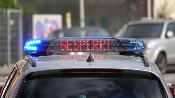 Auf einem Polizeifahrzeug steht "Gesperrt". © NDR Foto: Carsten Salzwedel