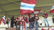   Weisse Flensburg fans with scarves and flags on the Tribühne © NDR 