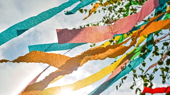 Die bunten Krepp-Papier Bänder und Äste eines Maibaums wehen im Wind. © photocase Foto: complize