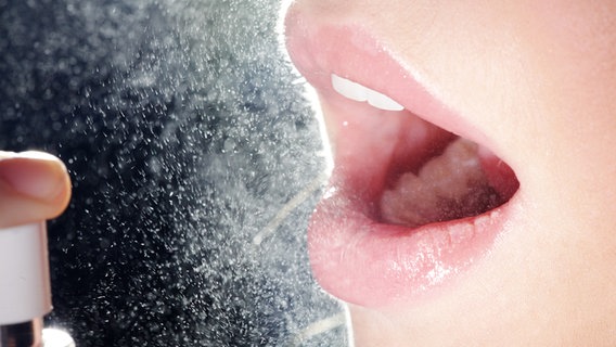 Eine Frau sprüht sich ein Mundspray in den geöffneten Mund. © Fotolia Foto: Nick Freund