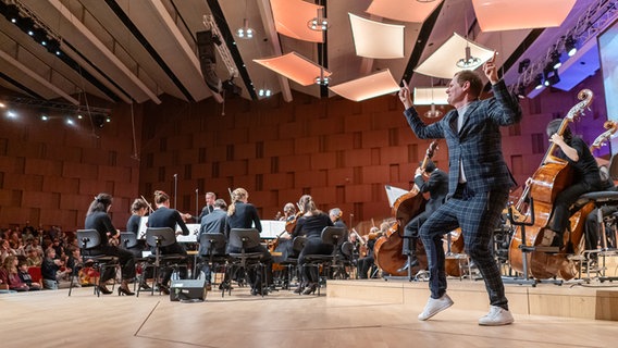 Orchester-Detektiv Malte Arkona tanzt auf der Bühne im Großen Sendesaal des NDR Konzerthauses © NDR Foto: Micha Neugebauer