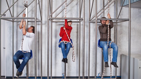 Menschen hängen an einem Seilzug, einer Experimentierstation in der Phänomenta in Flensburg © Phänomenta e.V. 