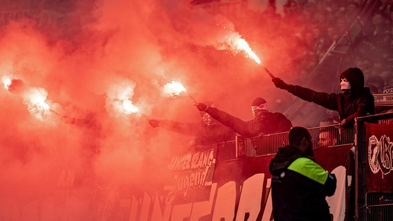 Fußball-Anhänger zünden beim Spiel Hannover gegen Braunschweig Pyrotechnik im Stadion. © picture alliance/dpa 
