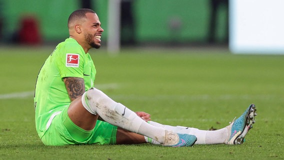 Wolfsburgs Stürmer Lukas Nmecha sitzt auf dem Rasen. © IMAGO / RHR-Foto 