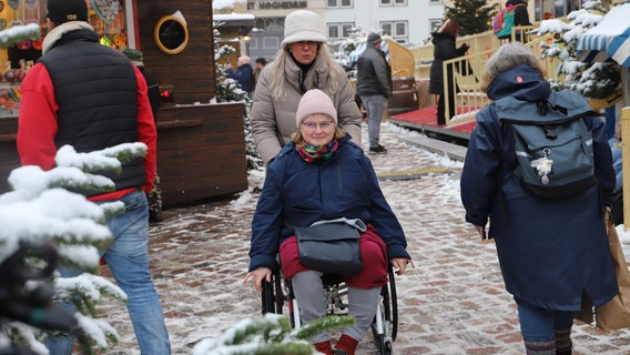 Chrstiane von Possel schiebt Eileen Lensch im Rollstuhl über den Weihnachtsmarkt © NDR Foto: Marina Heller