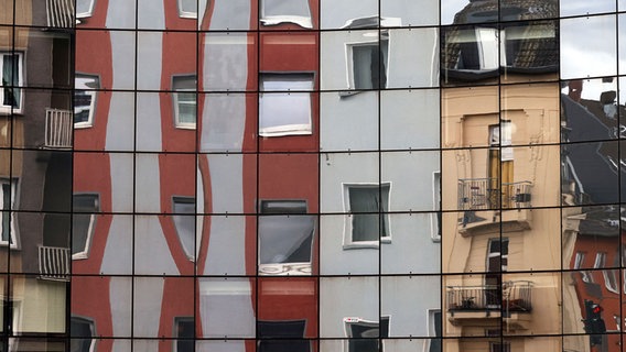Mietshäuser in Köln spiegeln sich in einer Glasfassade. © picture alliance / Panama Pictures Foto: Christohp Hardt