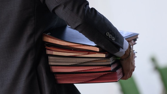 Ein Mann trägt viele Mappen unter dem Arm. © picture alliance/dpa | Robert Michael Foto: Robert Michael
