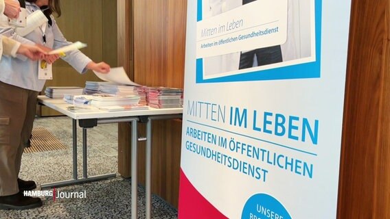 Ein Werbeaufsteller mit der Aufschrift: "Mitten im Leben - Arbeiten im öffentlichen Gesundheitsdienst". © Screenshot 