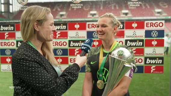 Alexandra Popp, Kapitänin beim VfL Wolfsburg, im Interview nach dem Pokalsieg. Den Pokal hält sie im Arm. © Screenshot 
