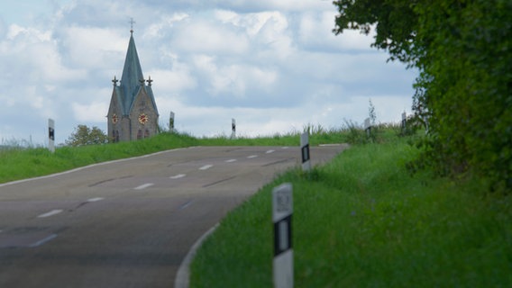 Landstraße mit Blick auf eine Kirche © picture alliance / imageBROKER | A. Scholz Foto: imageBROKER | A. Scholz