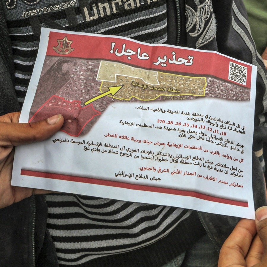 Palästinenser halten ein Flugblatt in der Hand, das von einem Militärflugzeug der israelischen Armee über dem Osten der Stadt Rafah abgeworfen wurde und sie auffordert, die Stadt zu evakuieren. © dpa Foto: Abed Rahim Khatib
