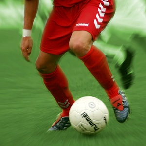 Fußballer mit roten Stutzen im Begriff den Ball zu spielen © panthermedia / Klosko Foto: Robert Klosko