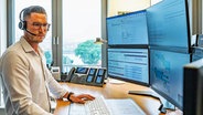 Ein Mann sitzt im Hamburg Vessel Coordination Center vor vielen Computerbildschirmen und arbeitet. © HVCC - Hamburg Vessel Coordination Center Foto: HVCC - Hamburg Vessel Coordination Center