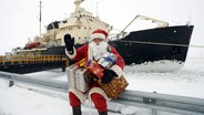 Ein Weihnachtsmann sitzt vor einem Schiff © picture-alliance / Lehtikuva | Martti Kainulainen Foto: picture-alliance / Lehtikuva | Martti Kainulainen