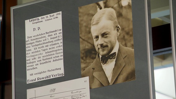 Ein Brief von 1910, unterzeichnet mit Ernst Rowohlt Verlag zusammen mit dem Foto eines lächelnden jungen Mannes mit Fliege ( Ernst Rowohlt) in einem Bilderrrahmen. © NDR Foto: Screenshot