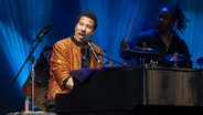 Der Sänger Lionel Richie sitzt bei einem Konzert am Klavier. © picture alliance  / Photoshot 