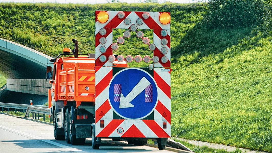 Ein Baustellenen Fahrzeug auf der Standspur einer Autobahn. 