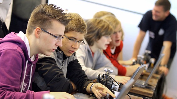 Schüler üben bei einer Ausbildungsmesse an der Programmierung mobiler Roboter. © dpa-Bildfunk Foto: Bernd Wüstneck