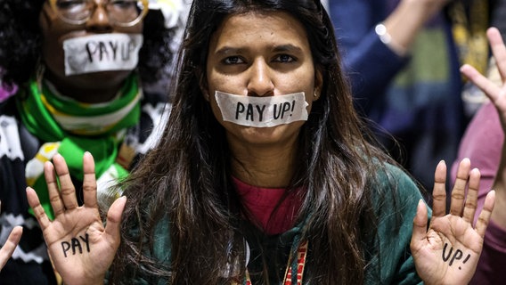 Eine Frau demonstriert auf der Weltklimakonferenz COP29 mit Klebeband über ihrem Mund, auf dem steht: "Pay up!" © picture alliance / ZUMAPRESS.com | Dominika Zarzycka Foto: Dominika Zarzycka