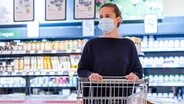 Ein Frau mit Schutzmaske im Supermarkt. © picture alliance Foto: Kirsten Nijhof