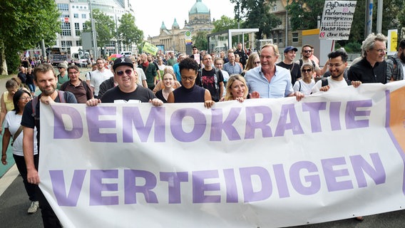 Ein Transparent "Demokratie verteidigen" bei einer Demonstration in Sachsen vor der Landtagswahl. Darunter Sebastian Krumbiegel, Sänger, und Burkhard Jung, Leipzigs Oberbürgermeister. © Picture alliance Foto: Sebastian Willnow