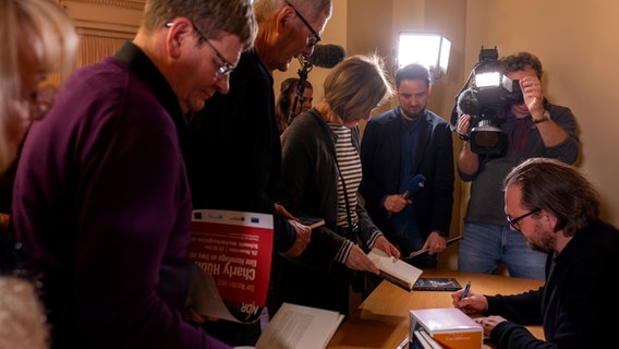 Charly Hübner signiert Bücher. © Silke Winkler Foto: Silke Winkler