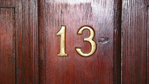 Zimmernummer 13 an einer Holztür © fotolia.de Foto: bartsadowski