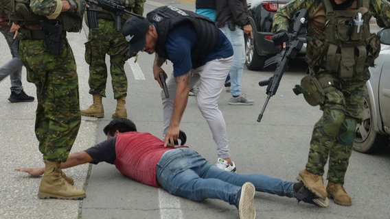 Polizisten in Ecuador verhaften einen Mann, der am Boden liegt © picture alliance Foto: Anadolu Jose Orlando Sanchez Lindao