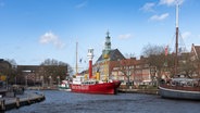 Im Binnenhafen von Emden ist bei sonnigem Wetter das rote Feuerschiff Amrumbank zu sehen. Die Wasseroberfläche kräuselt sich wegen des starken Windes. © Lornz Lorenzen Foto: Lornz Lorenzen