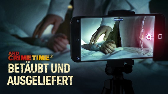 Ein Handy filmt mit, wie ein Arzt die Hand einer offenbar betäubten Patientin in einem Klinikbett berührt. © NDR/André Dekker/Markus Holzum 