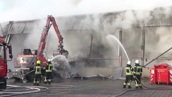 Einsatzkräfte der Feuerwehr kämpfen gegen einen Brand in einer Lagerhalle in Bardowick. © TV Elbnews 