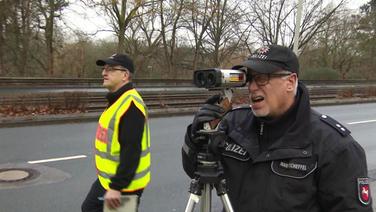 Zwei Polizisten bei der Verkehrskontrolle.  