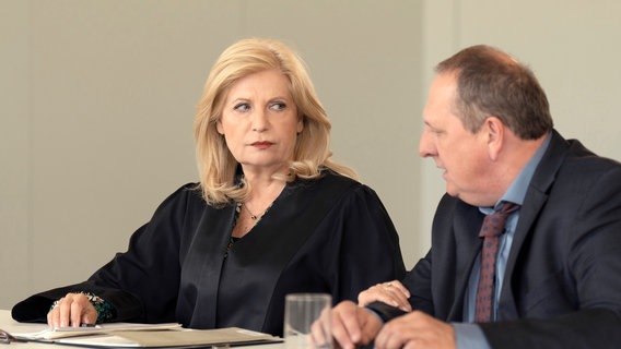 Isabel von Brede (Sabine Postel) verteidigt Richter Greinert (Thomas Kügel), dem vorgeworfen wird, er arbeite zu langsam und schaffe viel weniger Fälle als seine Kollegen. © ARD/Christine Schroeder 