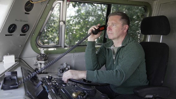 Roland Sandkuhl telefoniert im Führerstand seiner Lok. © NDR/Henning Orth/Mats Enderle 