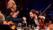 In der NDR Talk Show am 29.03.2013 sind Axel Prahl mit einer Gitarre, David Garrett mit einer Geige und Veronika Ferres zu sehen. © NDR/Uwe Ernst 