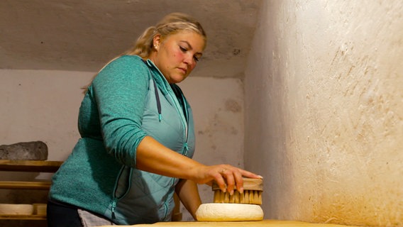 Nina Bartl vom Gschwandtnerhof am Tegernsee versucht sich heute auf der hofeigenen Alm am Käsemachen. Noch nicht alles klappt dabei auf Anhieb. © NDR/BR/isarflimmern/Oliver Biebl 