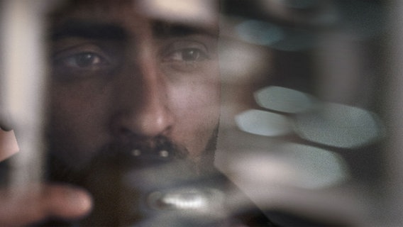 Sulaiman Tadmory steht hinter einer Glasscheibe. © NDR/Sulaiman Tadmory 