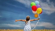 Ein Mädchen hält bunte Luftballons in die Luft © Fotolia.com Foto: drubig-photo