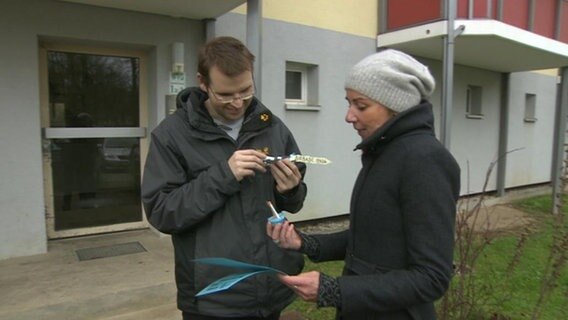 Alexander bekommt einen Gutschein für eine Reise überreicht.  