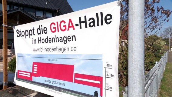 Ein Banner mit der Aufschrift ‘Stoppt die GIGA-Halle in Hodenhagen’ und einer Darstellung einer Halle. © Screenshot 