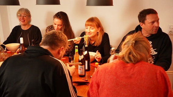 Menschen sitzen am Tisch und essen Ramen © NDR 