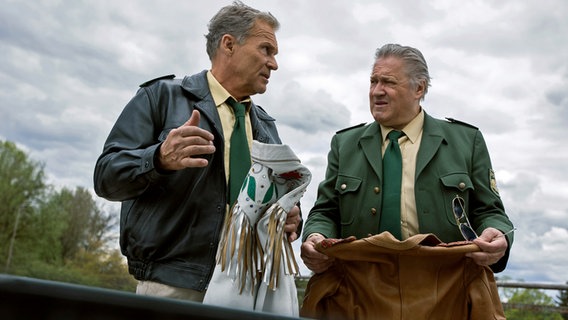 Hubert (Christian Tramitz, l.) und Girwidz (Michael Brandner, r.) finden im Kofferraum des Wagens mehrere Designerjacken. © ARD/Kai Neunert 