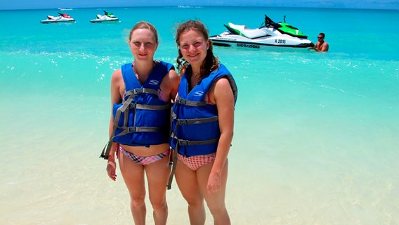 Famulantin Viktoria Willeke, die ein Praktikum im Bordhospital macht, und Küchenpraktikantin Elisabeth am Strand in Aruba mit Schwimmwesten. © BR/Christian Hattesen Foto: Christian Hattesen